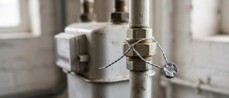 Газовый счетчик с установленной пломбой на трубе
