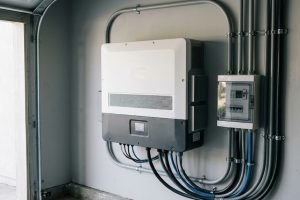 Инвертор на стене рядом с автоматами защиты и кабелями
