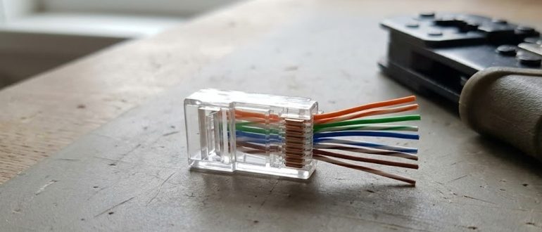 Коннектор RJ45 с цветными жилами витой пары перед обжимом