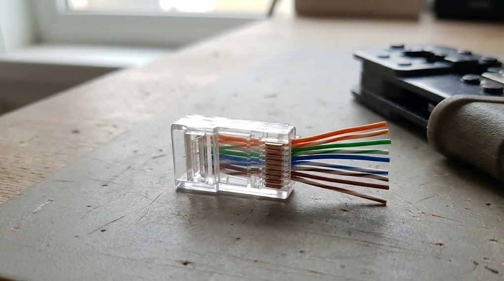 Коннектор RJ45 с цветными жилами витой пары перед обжимом